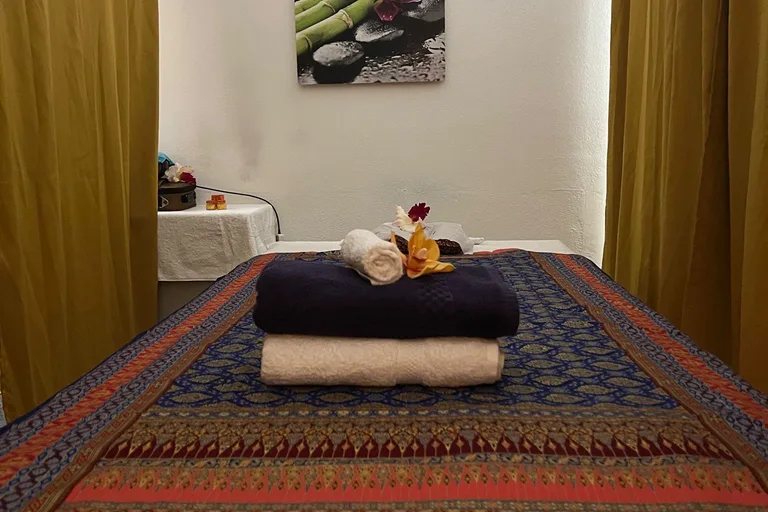 Behandlungsraum mit Massageliege und Thai-Dekorationen