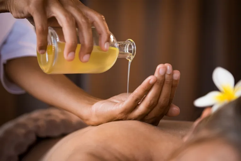 Aromaöl-Massage mit warmem Öl am Rücken